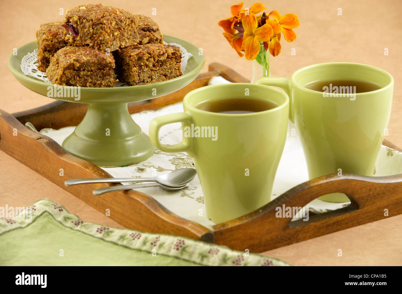Healthy homemade granola squares with mugs of tea on wooden tray Stock Photo