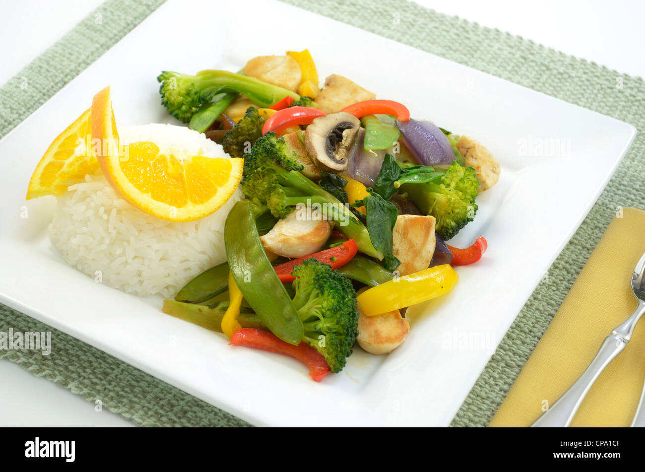 Chicken stir fry with rice on square white plate Stock Photo