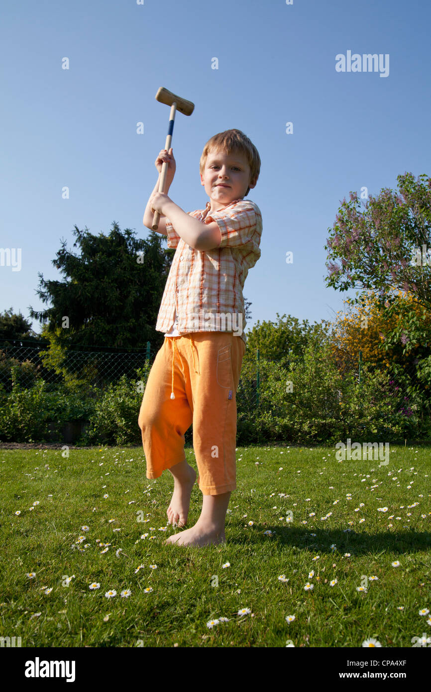 young boy hitting with a mallet Stock Photo - Alamy