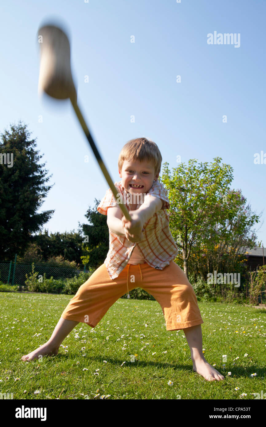 young boy hitting with a mallet Stock Photo Alamy