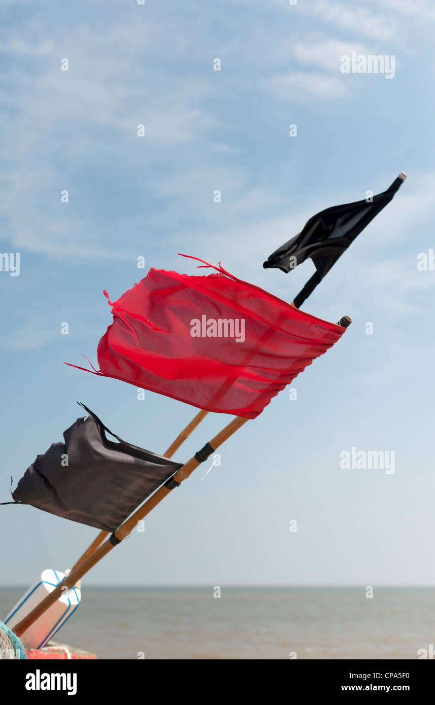 Black and red flags used to mark fishing buoys on a boat on the east coast of the UK Stock Photo