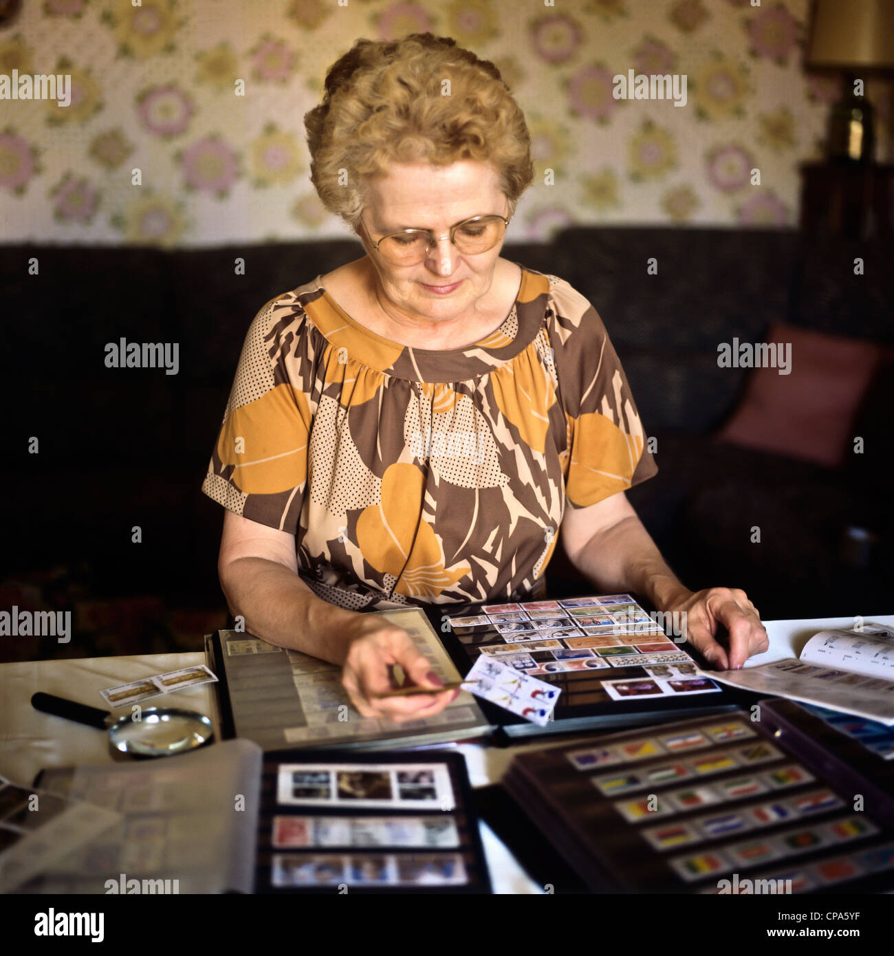 MR elderly woman with postage stamp collection Stock Photo