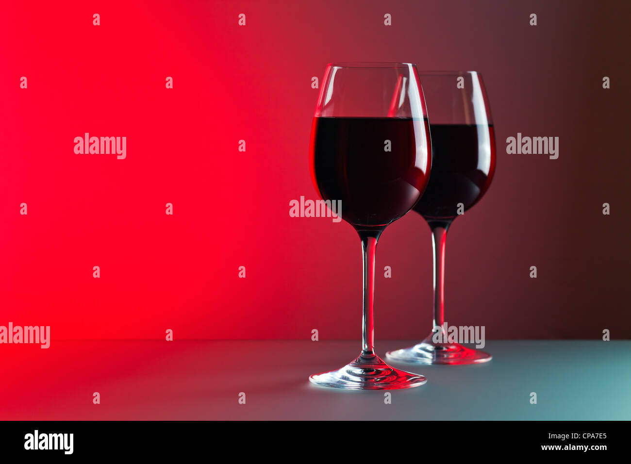 glasses with red wine against of red background Stock Photo Alamy