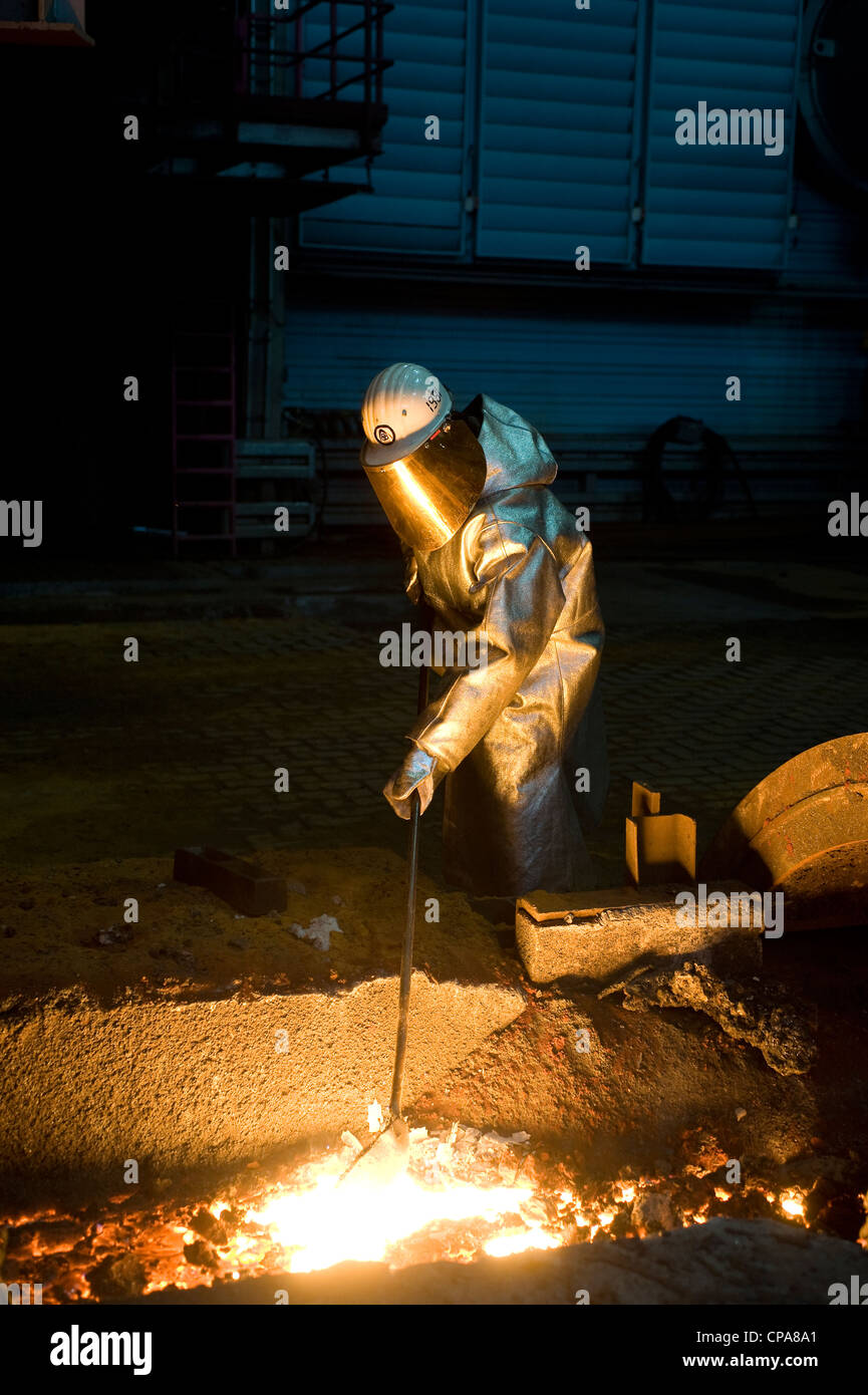 A worker taking a raw iron sample, Duisburg, Germany Stock Photo