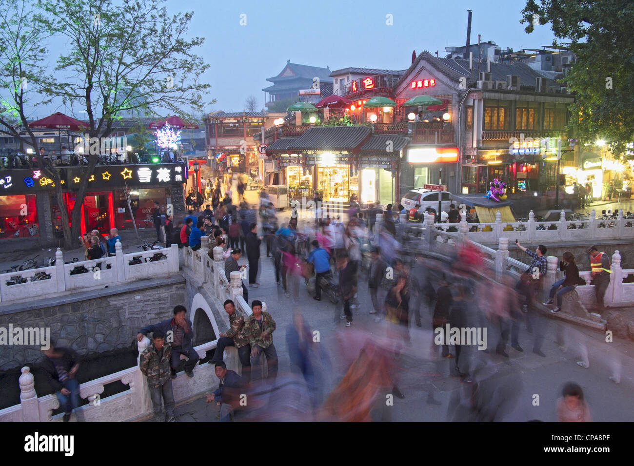 Busy street on historic bridge beside popular tourist location at Houhai Lake in Beijing China Stock Photo