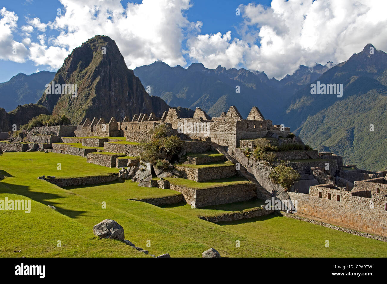 The Inca ruins of Machu Picchu with Huaynu Picchu and the Andes Mountains behind in the Sacred Valley of Peru at sunset. Stock Photo