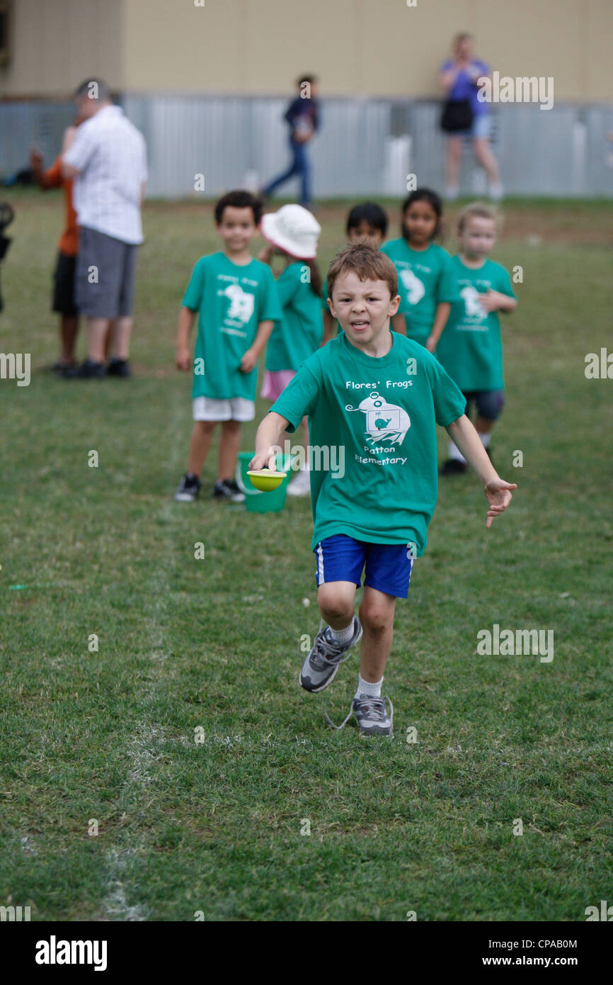 Multi-ethnic kindergarten age school children participate in physical activities outdoors during track and field day Stock Photo