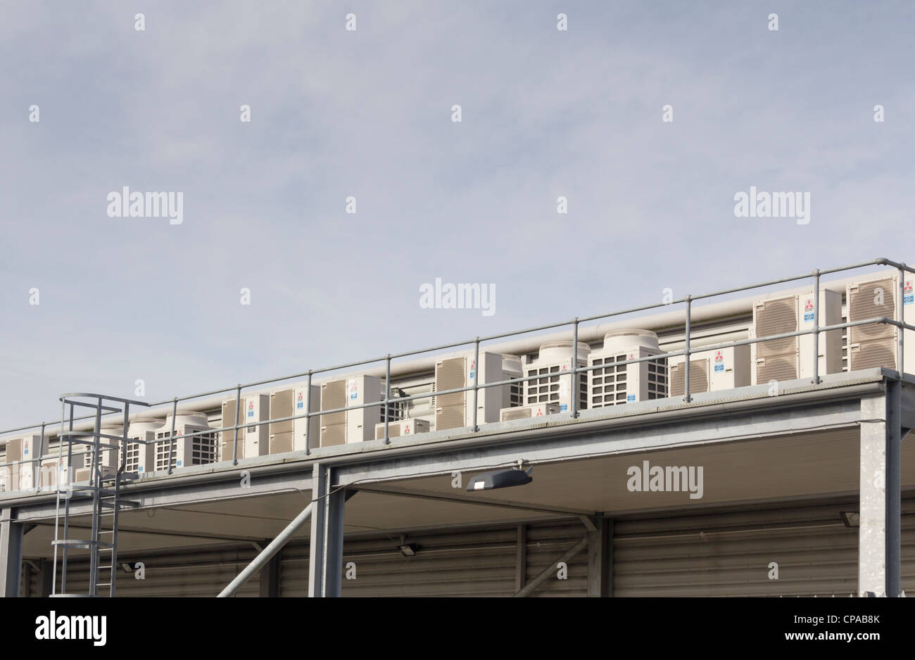 A row of Mitsubishi air conditioning units on an exterior  mezzanine floor level of an industrial building. Stock Photo