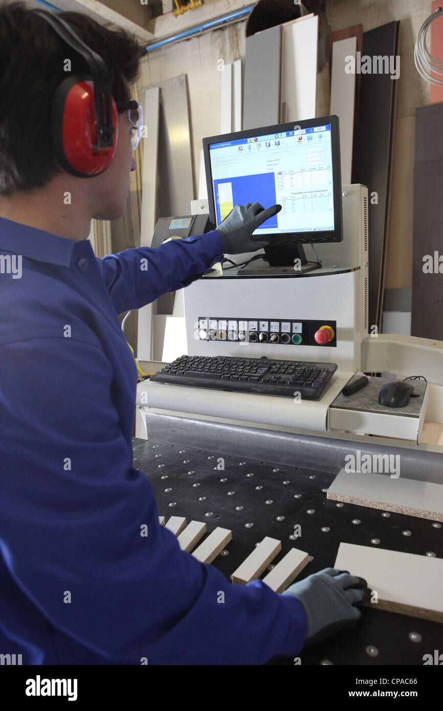 Man stood by computer operated factory machine Stock Photo - Alamy