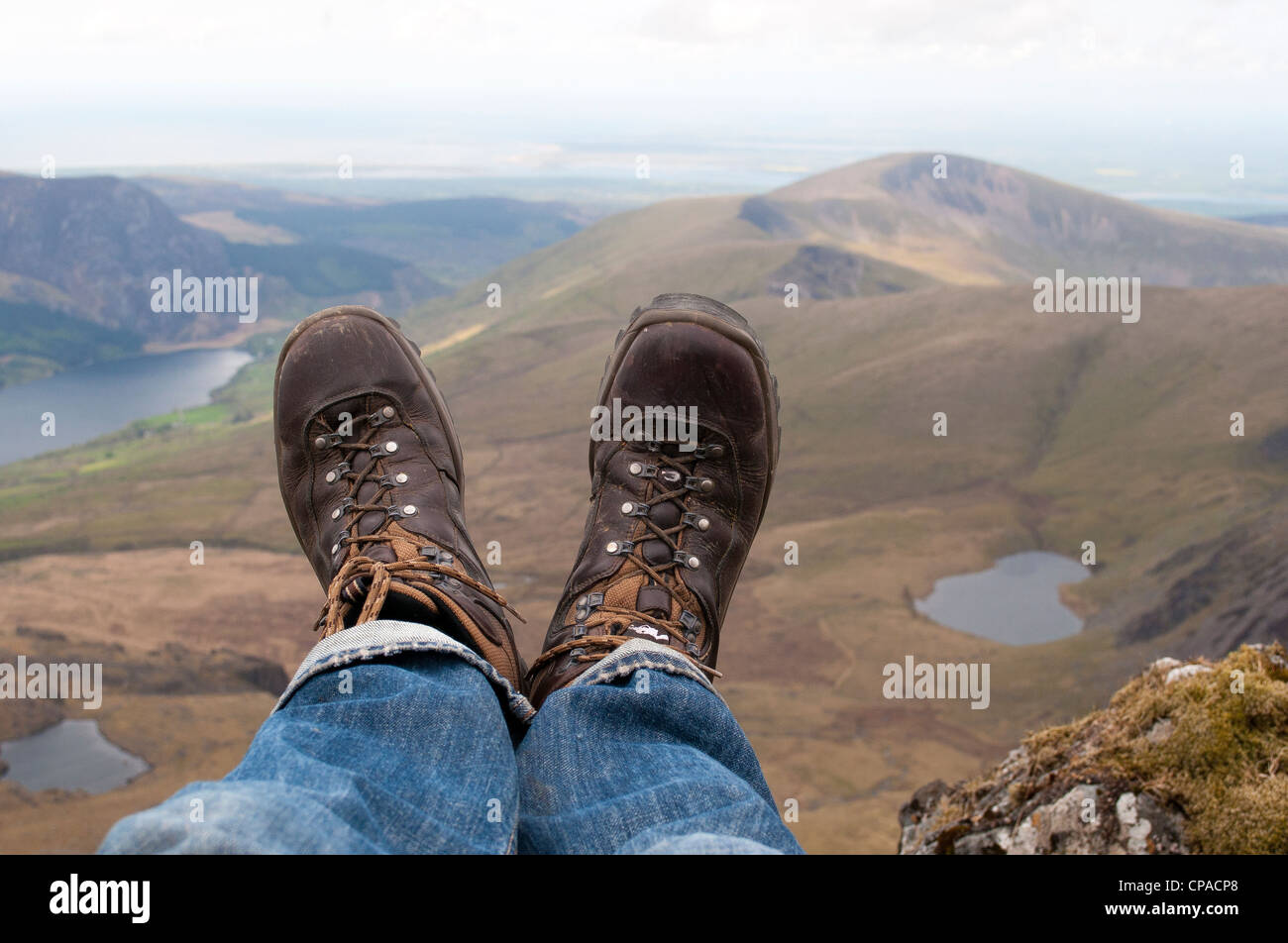 Sitting down admiring the view across the Welsh landscape from halfway up Mount Snowdon in North Wales Stock Photo