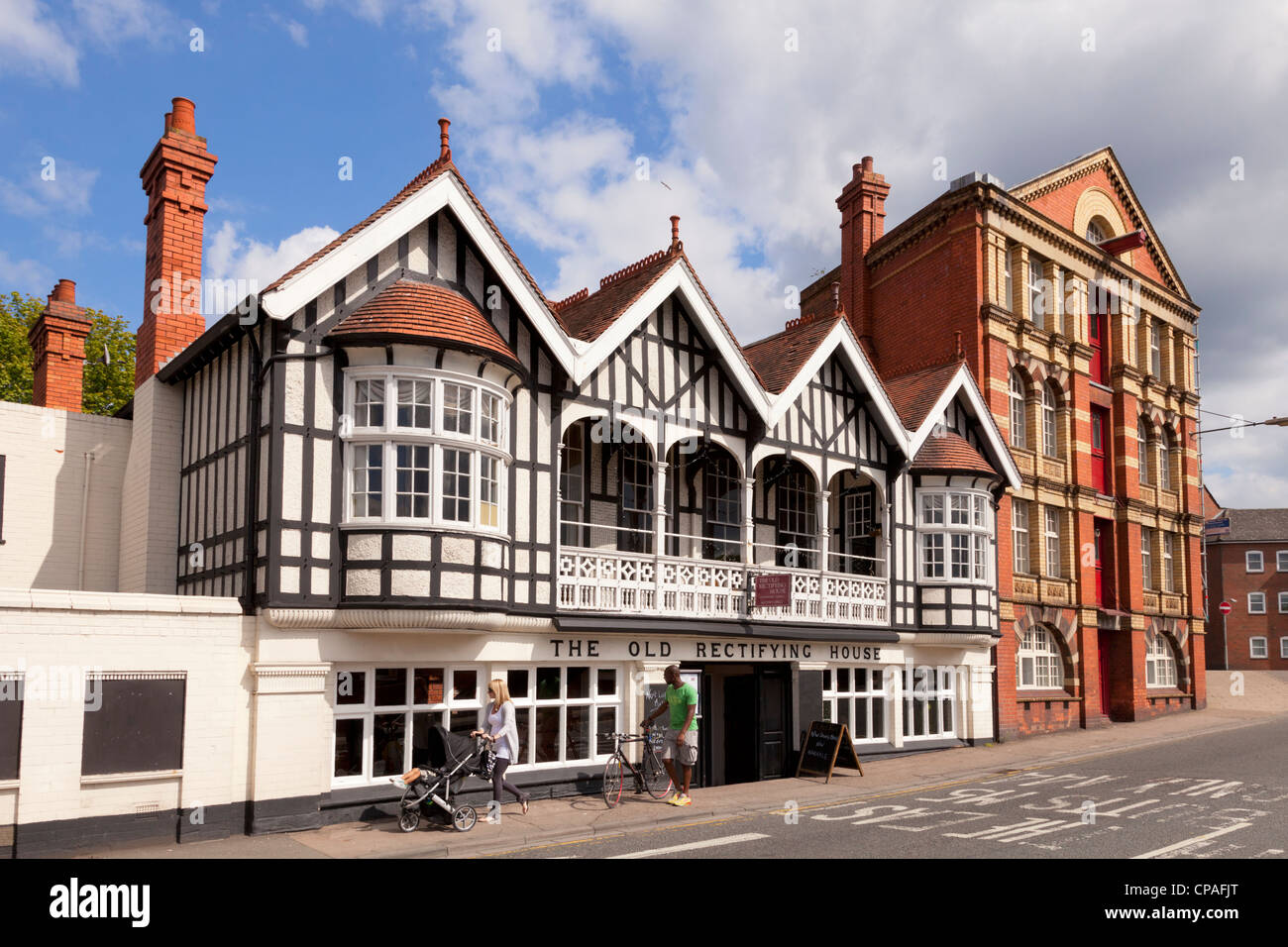 The Old Rectifying House in Worcester, England, with two people walking