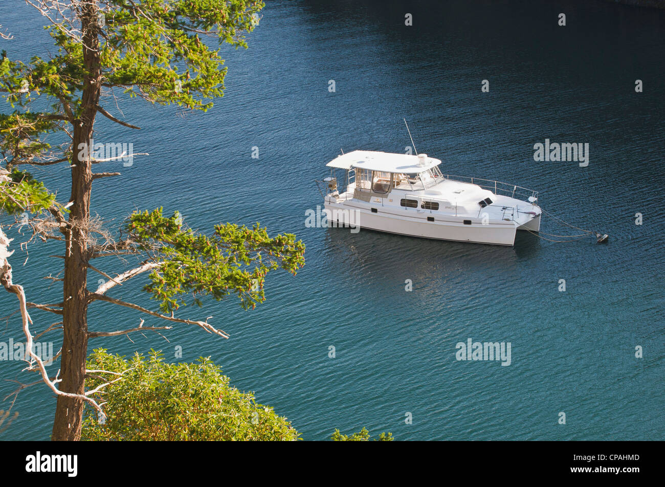 USA, WA, San Juan Islands. Motor catamaran moored in Snoring Bay of Sucia Island State Park. Stock Photo