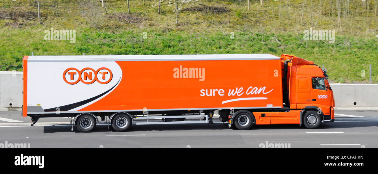 TNT hgv parcel delivery lorry truck and articulated trailer driving along M25 motorway Essex England UK Stock Photo