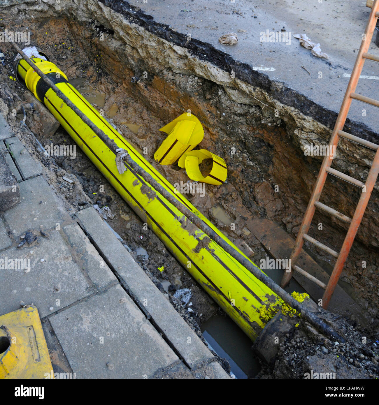 Section of old cast iron pipe removed for yellow plastic gas main to