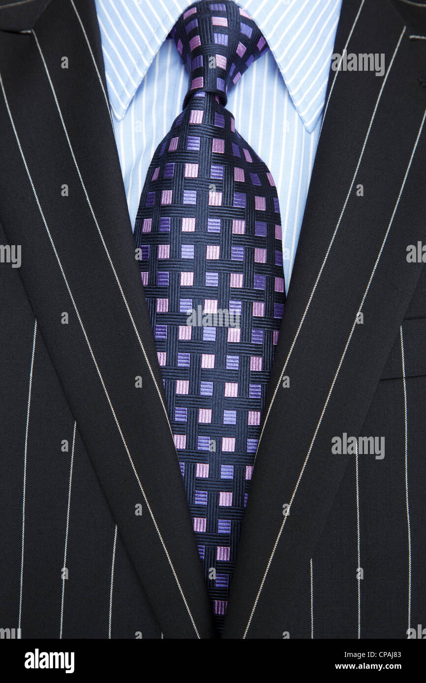 Photo of a black pinstripe suit with blue striped shirt and purple and blue patterned tie Stock Photo