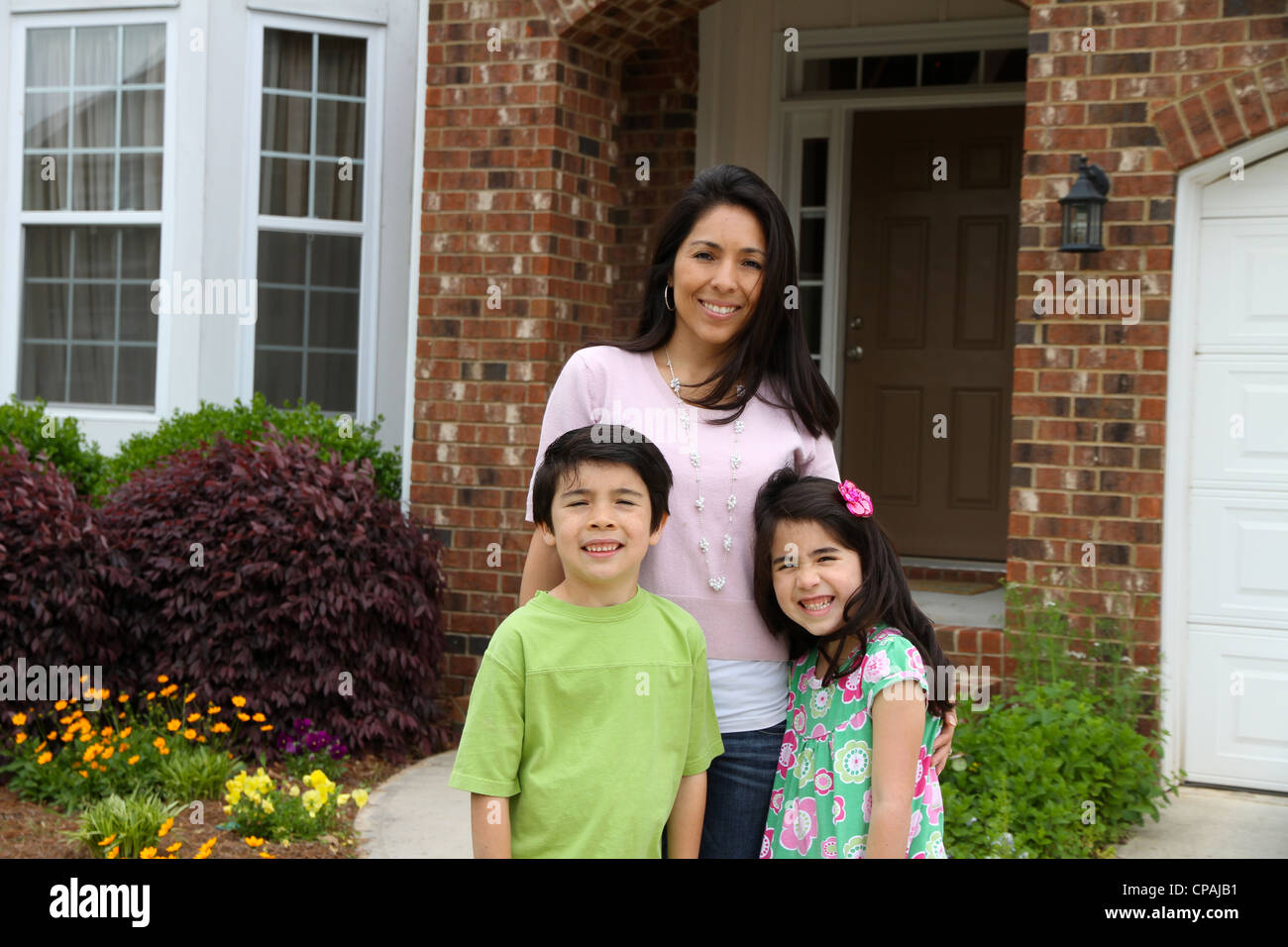 Family standing outside their home in summer Stock Photo - Alamy