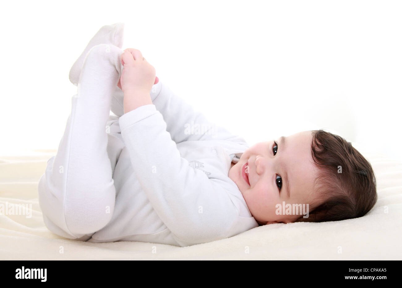 Happy baby playing with his feet Stock Photo - Alamy
