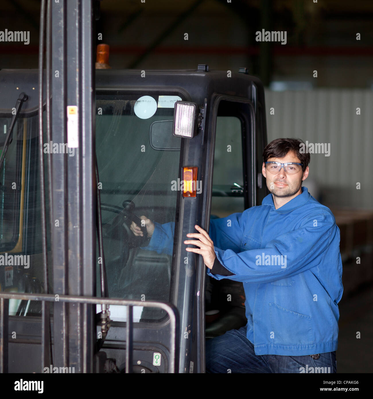 Blue collar worker with fork lift truck Stock Photo