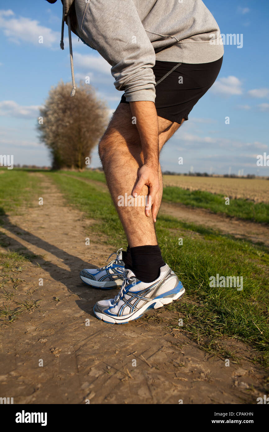 Man having cramp while running Stock Photo Alamy