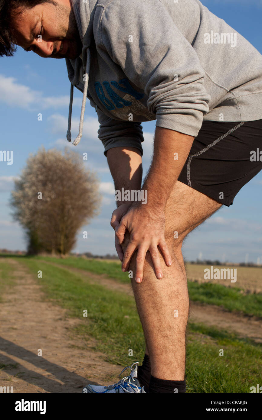 Man having cramp while running Stock Photo Alamy