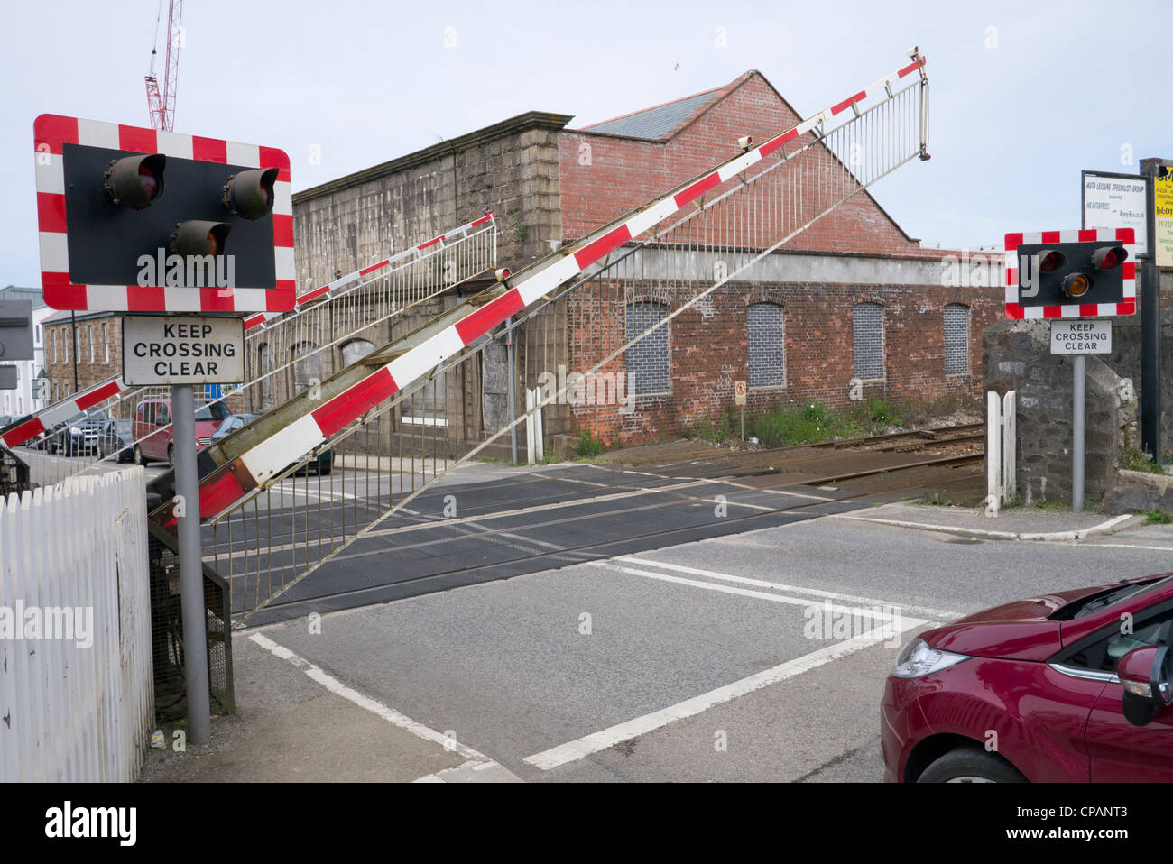 British railway level crossing barrier gate being raised after a train has passed through in Camborne, UK. Stock Photo