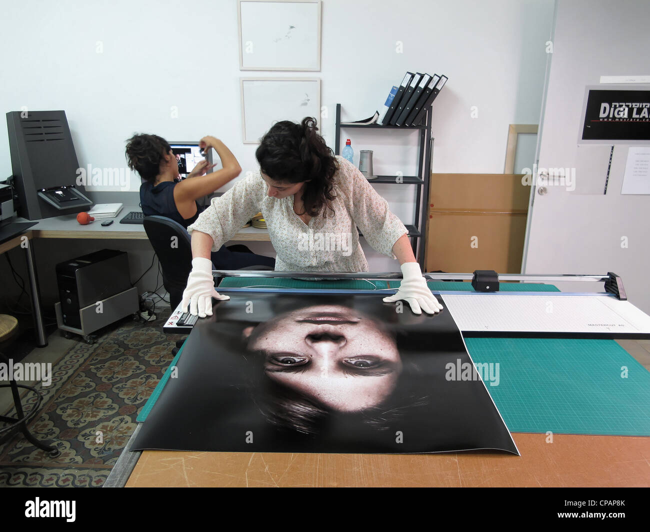 Photography Student handling a large print at the digital lab of Naggar school for Photography or Musrara art school in West Jerusalem Israel Stock Photo