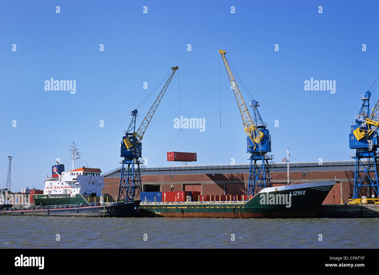 cranes unloading containers from container ship at the port of hull