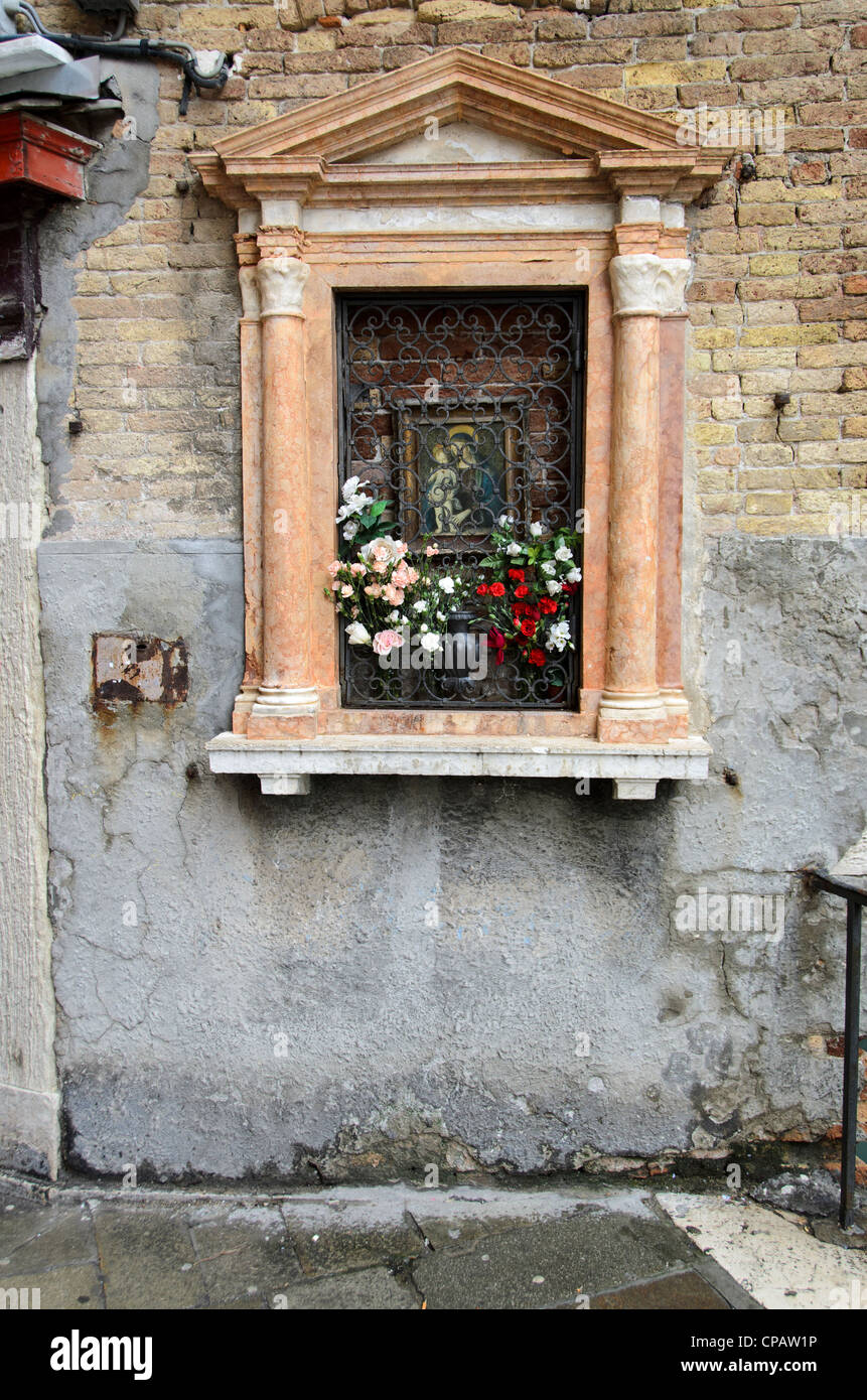 Catholic religious shrine in brick wall - sestiere San Marco, Venice - Italy Stock Photo