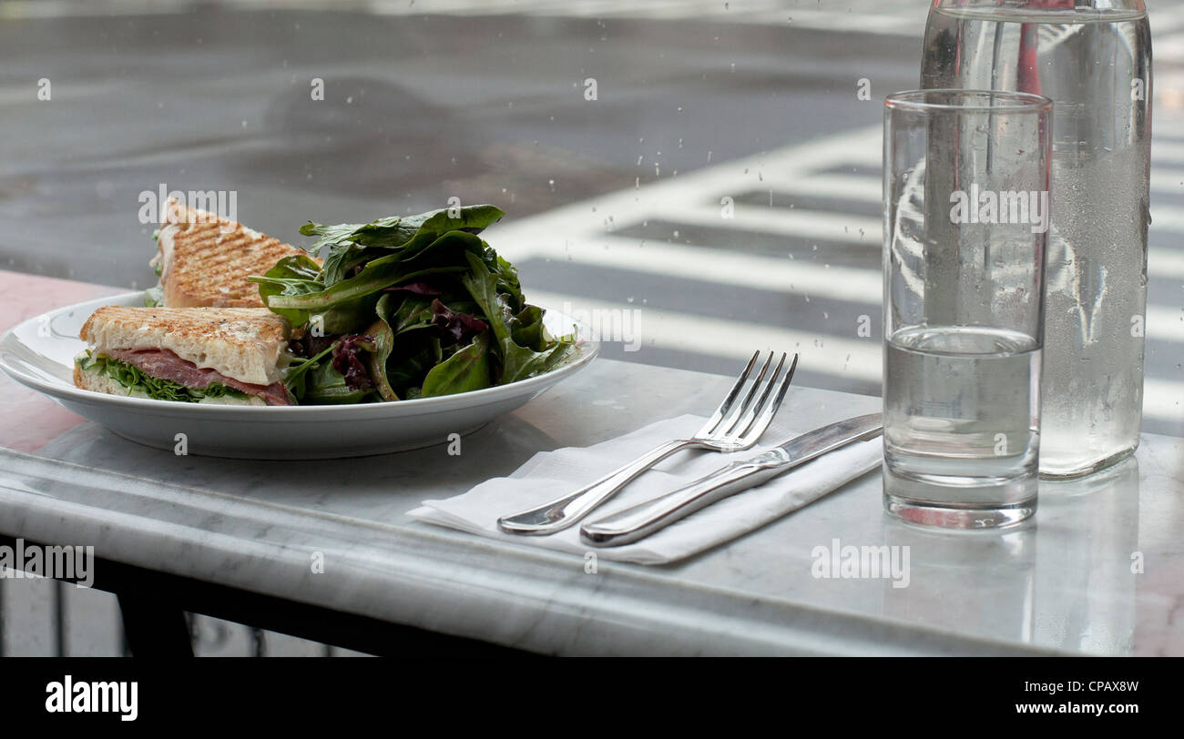 A lunch of salad and a panini waits on a counter. Stock Photo