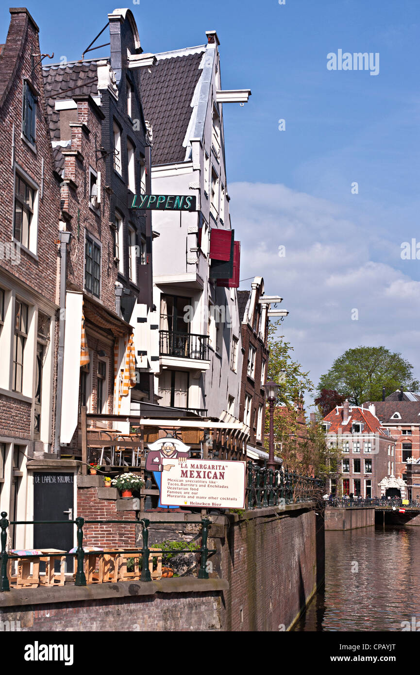 AMSTERDAM, NETHERLANDS - MAY 07, 2012:  Canalside houses in the Nieuwe Zijde area. One of the houses is now  the 'Le Margarita' Restaurant Stock Photo
