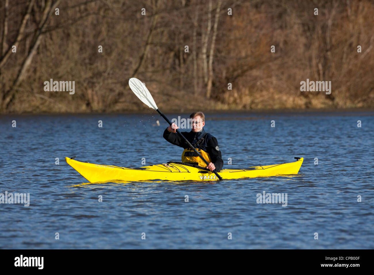 Man in yellow kayak kayaking on lake in spring, Germany Stock Photo