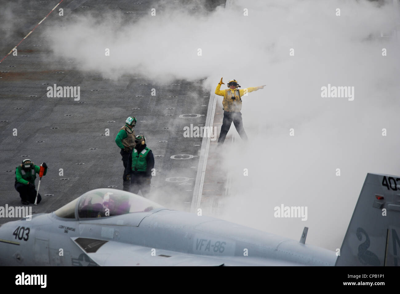 Sailors aboard the aircraft carrier USS Nimitz (CVN 68) direct an F-18/E Super Hornet assigned to the Salty Dogs of Air Test and Evaluation (VX) 23 squadron into launching position. Nimitz is conducting carrier qualifications off the coast of southern California. Stock Photo