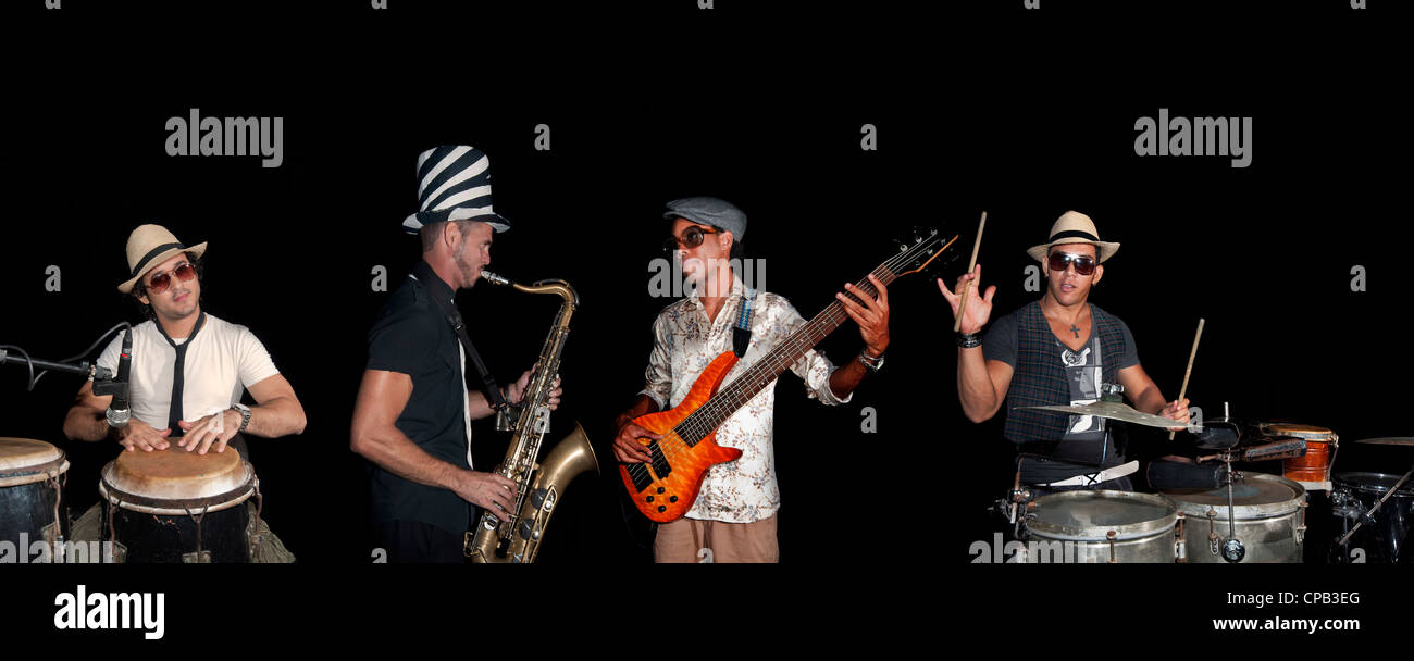 Portrait of four musicians playing isolated against black background Stock Photo