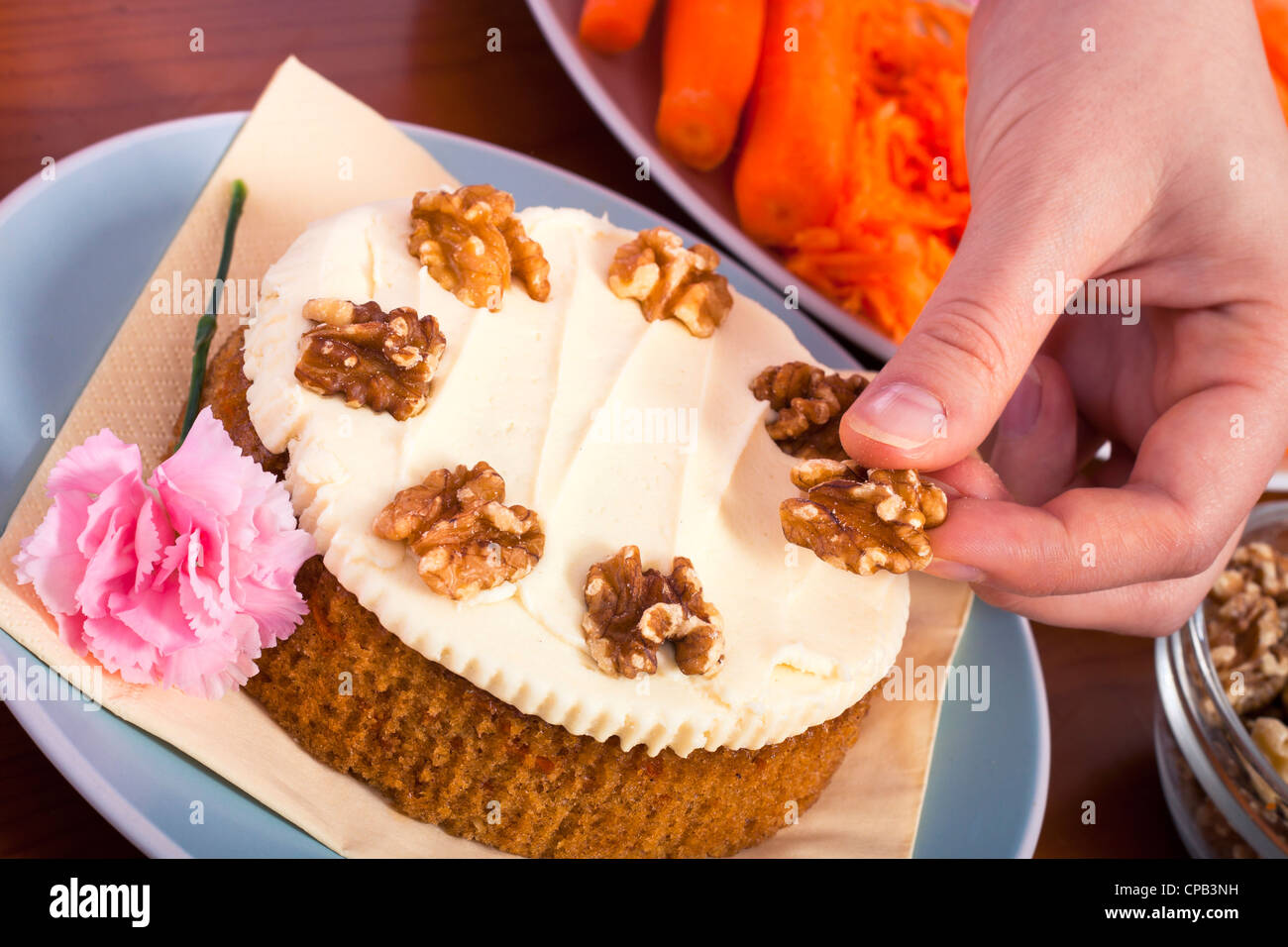 Close up of decorating carrot cake with walnuts. Stock Photo