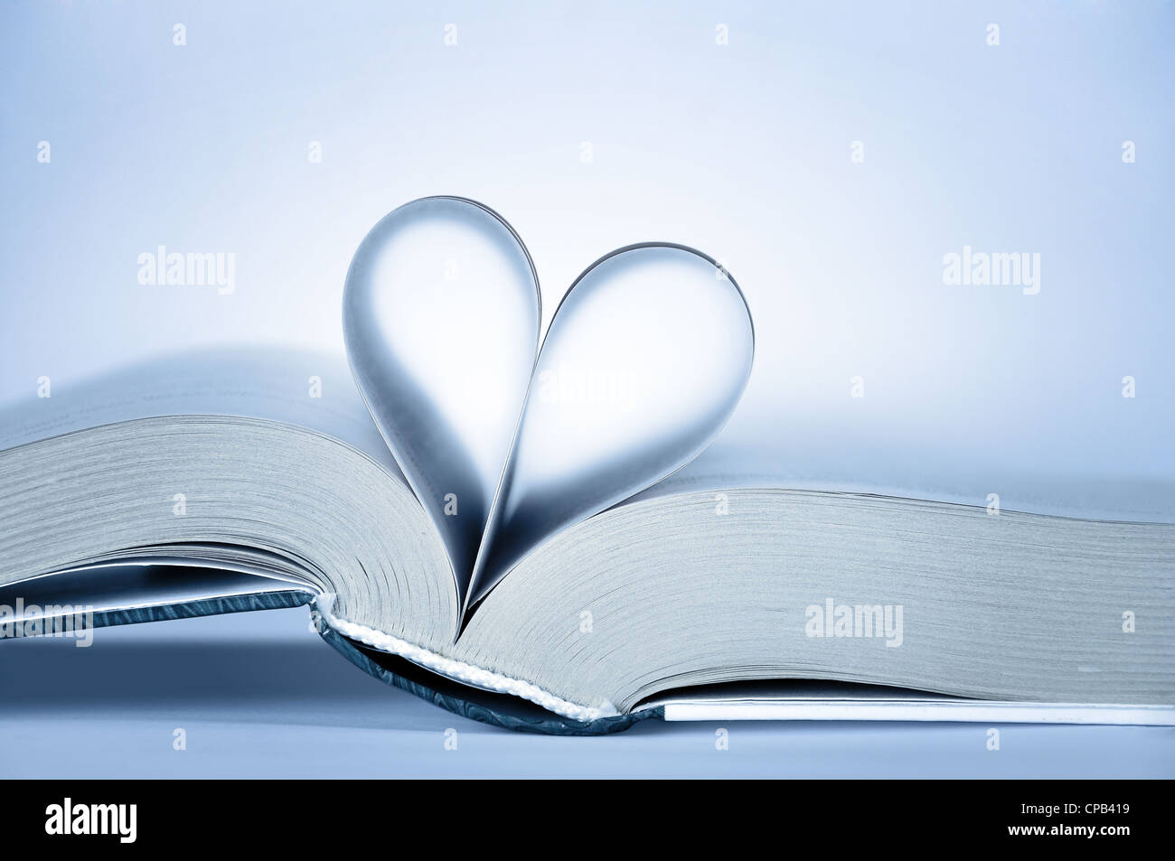 book with heart shaped pages over light background Stock Photo - Alamy