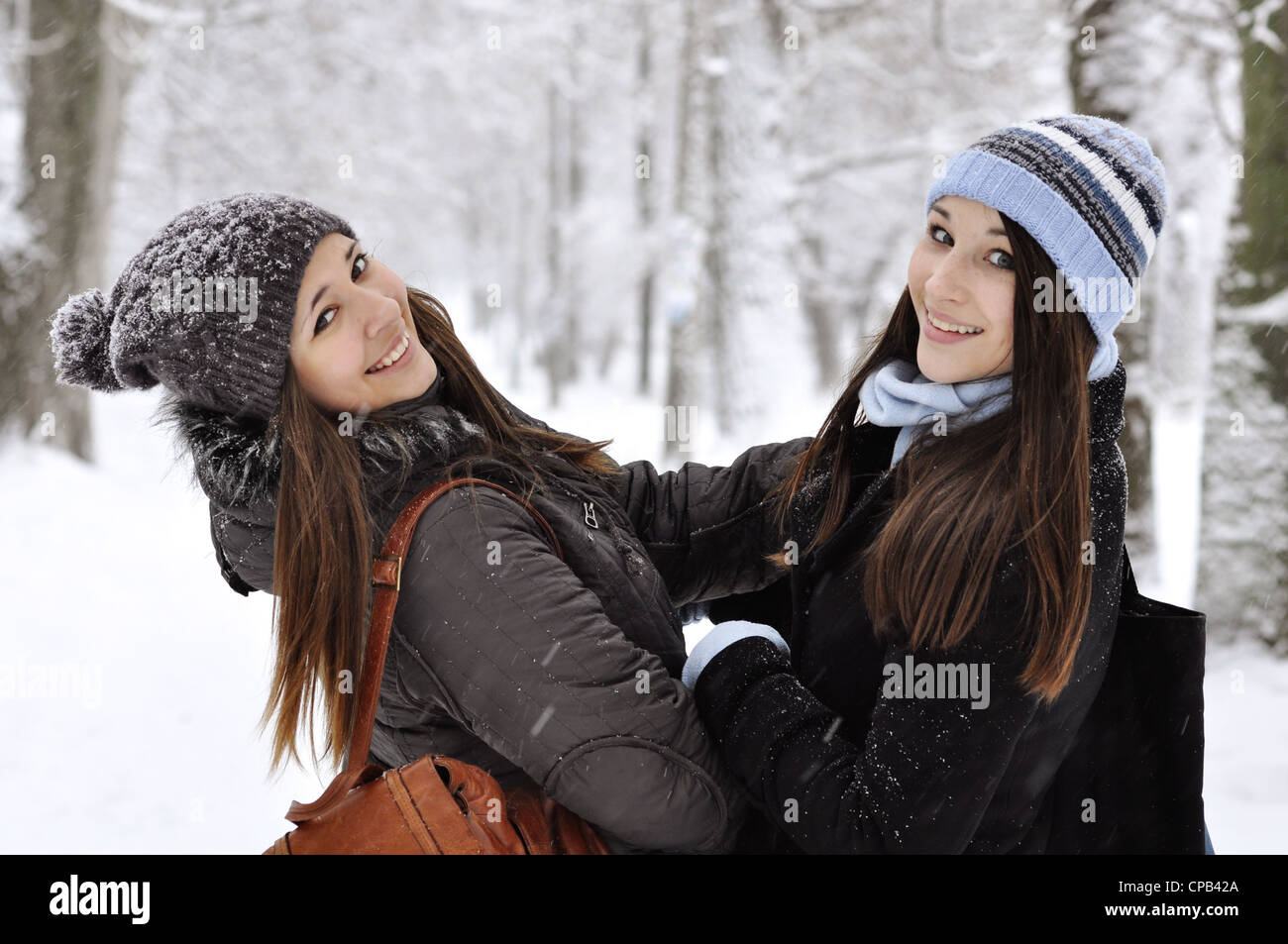 Two beautiful young girls in winter park Stock Photo - Alamy