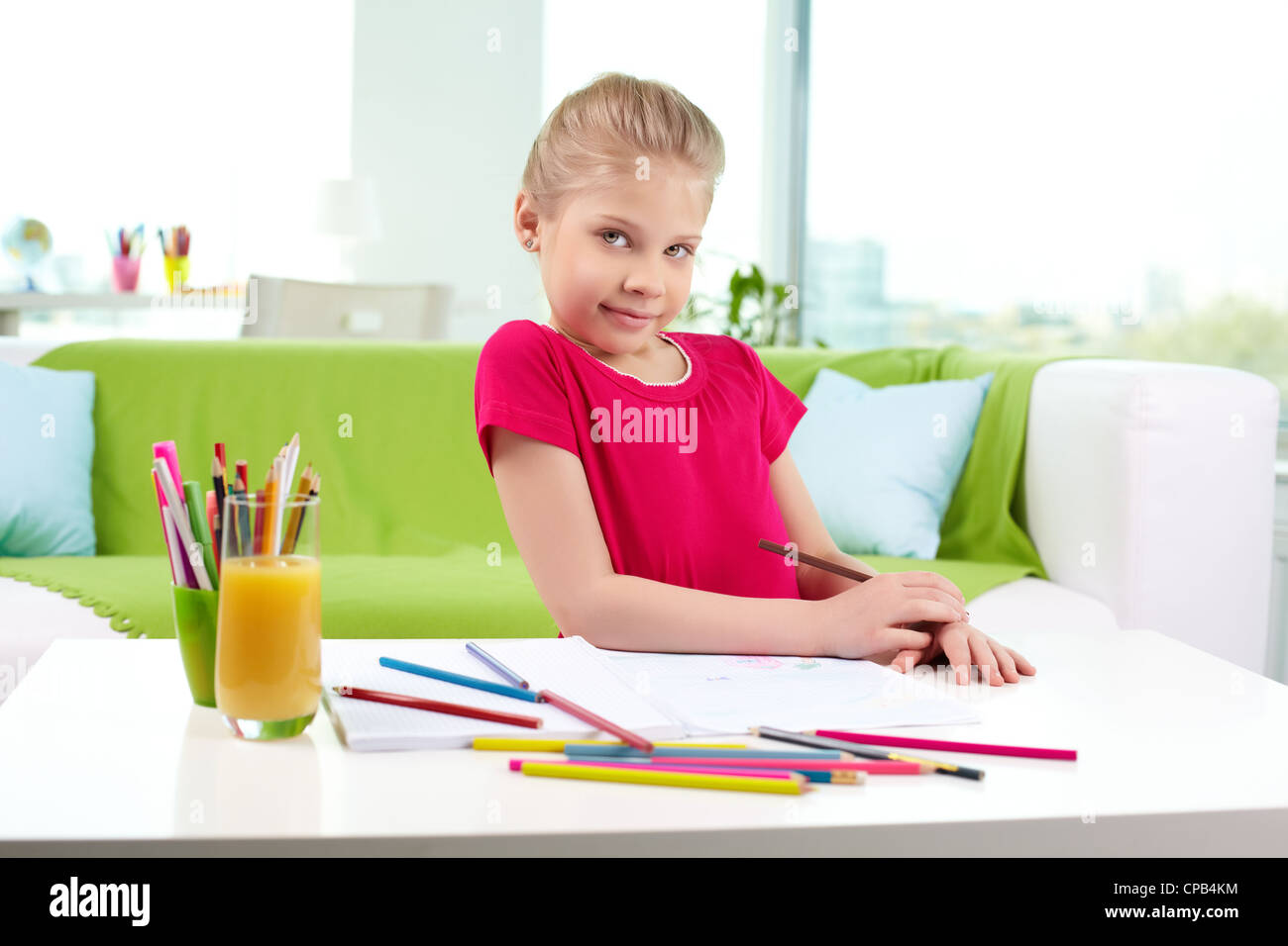 Lovely girl looking at camera while drawing with colorful pencils Stock ...