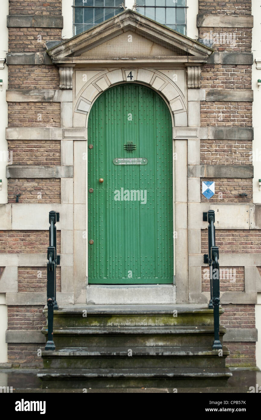 Green wooden Arched door to canal House in Amsterdam Stock Photo
