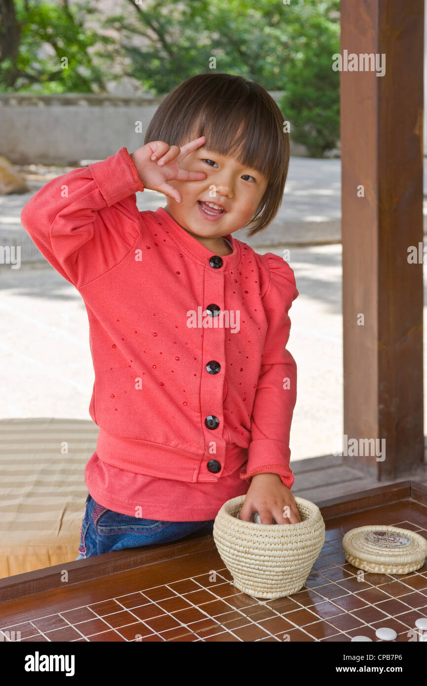 A cute young Chinese girl poses for the camera at a rest area on Mount Kongtong near Pingliang city in China. Stock Photo