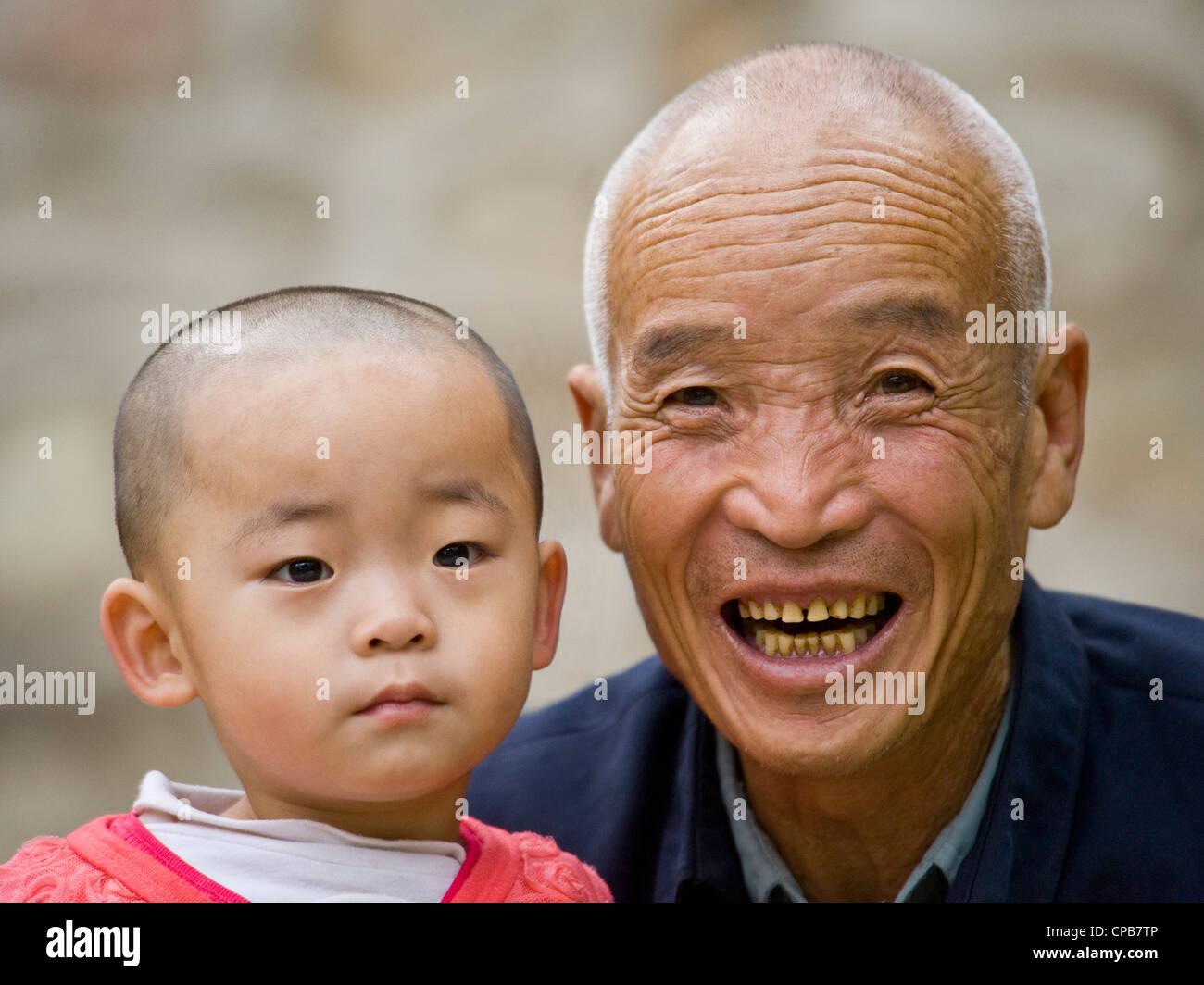 A young Chinese boy and his grandfather pose for the camera in Pingliang. Stock Photo