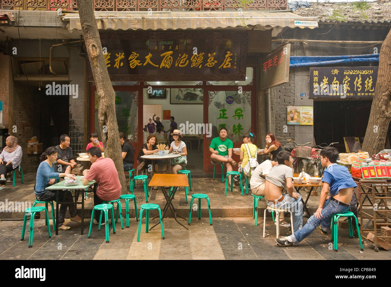Local Chinese people at an outside restaurant of Moslem Street (Huimin Jie) in Xian. Stock Photo
