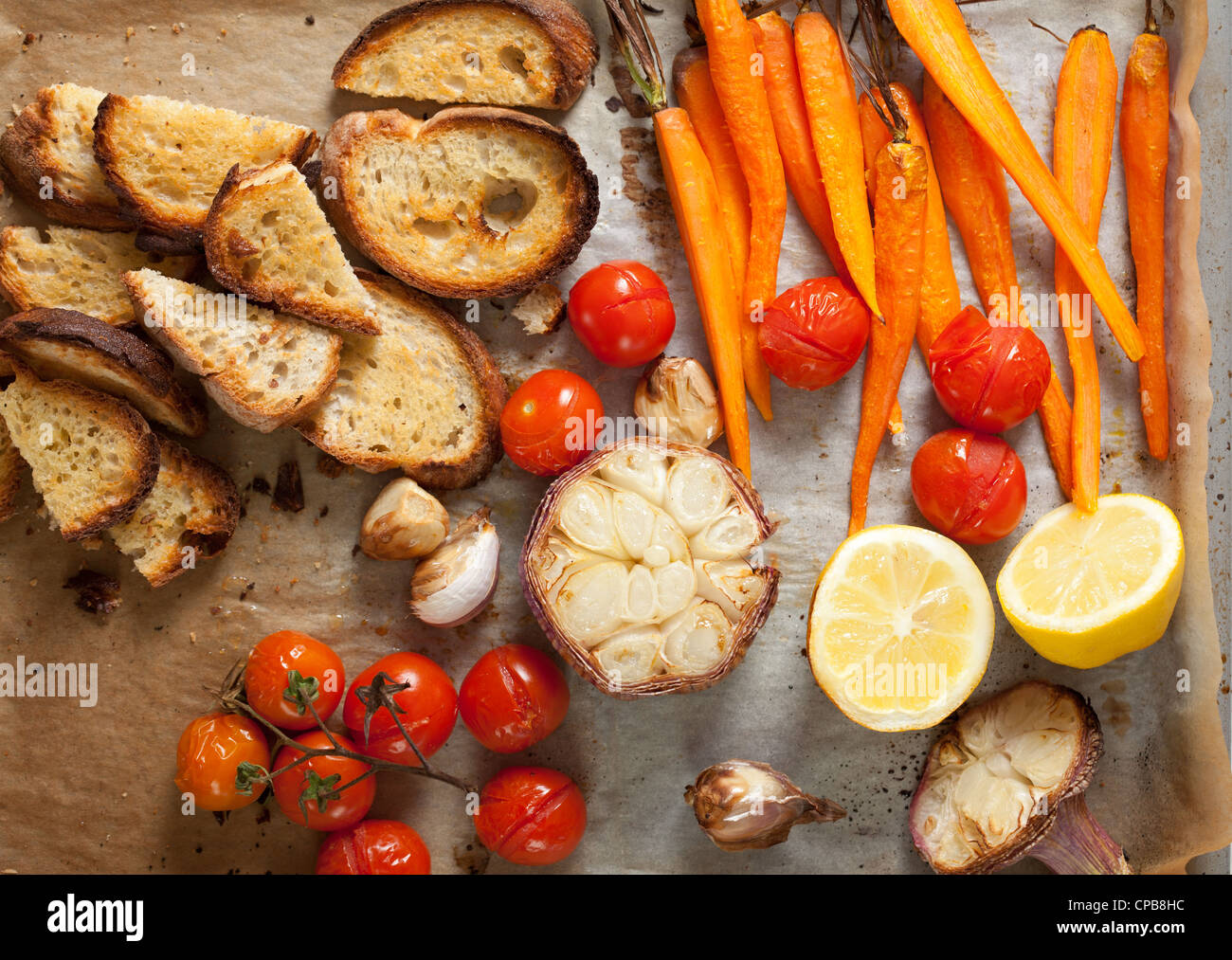 oven baked bread and vegetables withc garlic, lemon, tomatoes and carrots Stock Photo