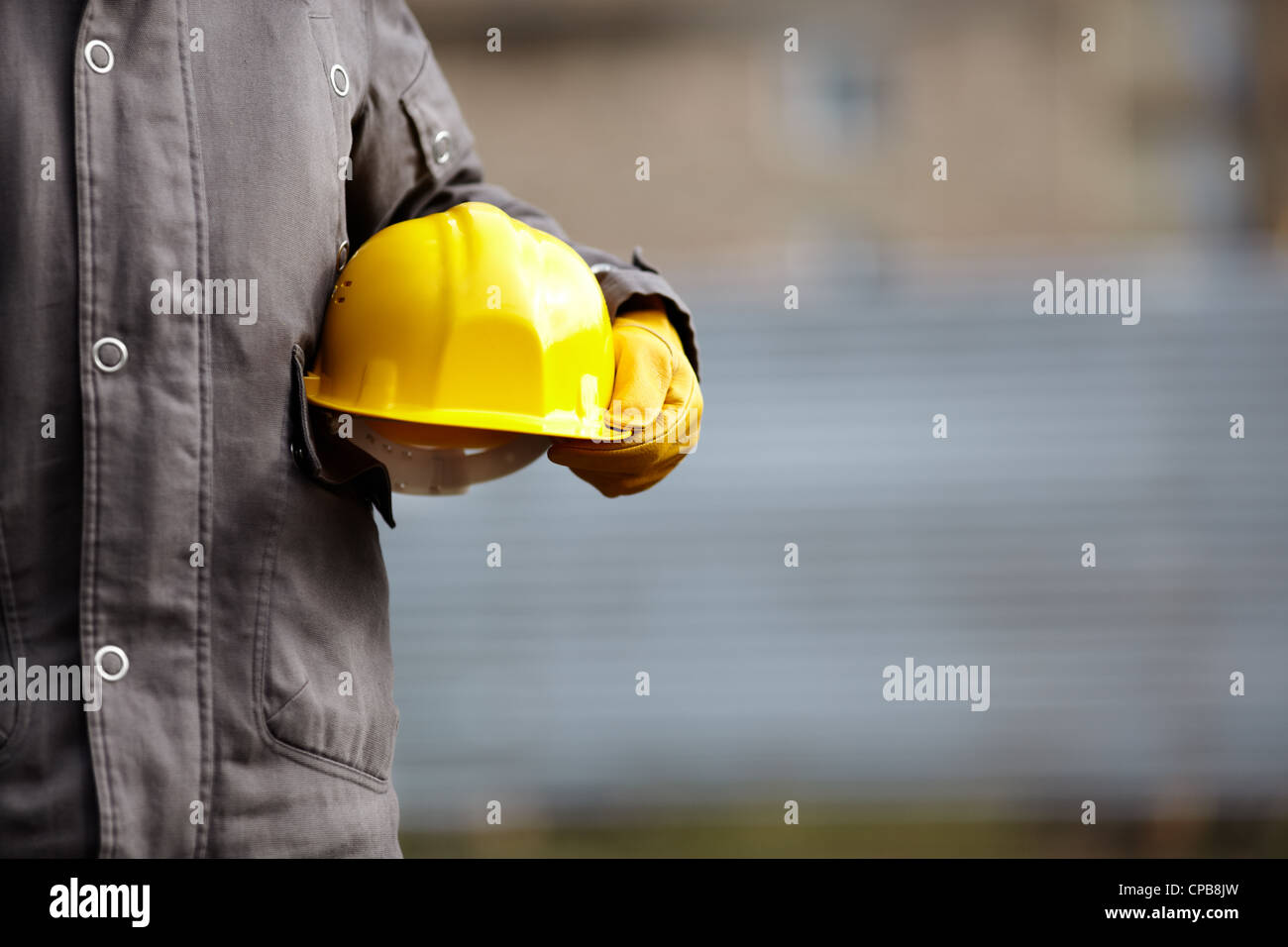 hand of builder with yellow hardhat, natural light,selective focus Stock Photo