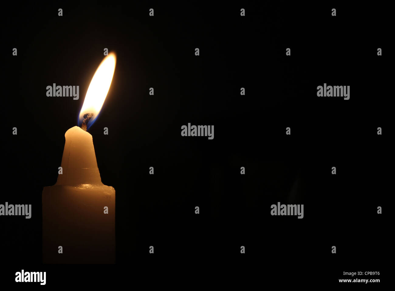 A candle lit in darkness Stock Photo Alamy