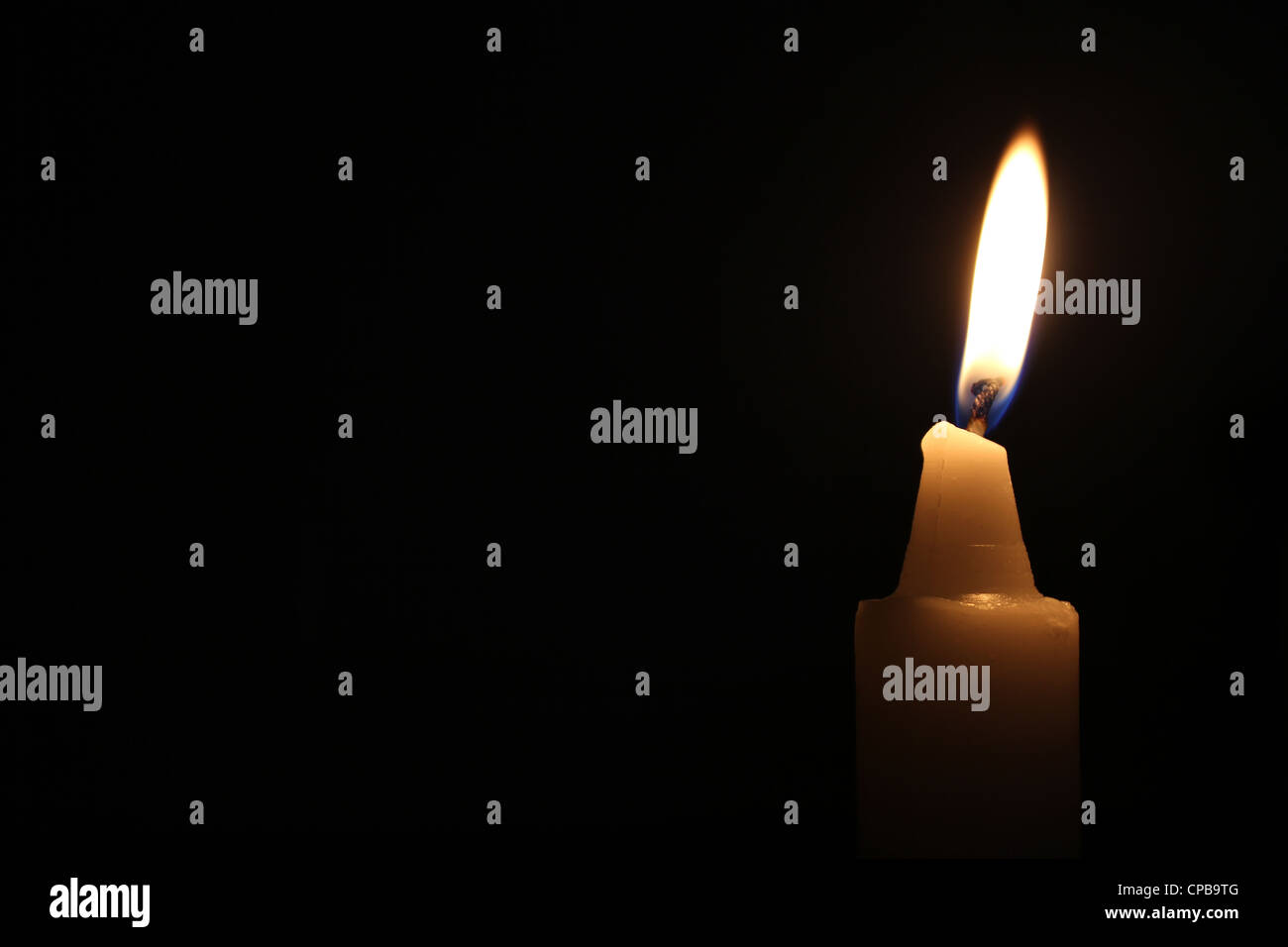 A candle lit in darkness Stock Photo Alamy