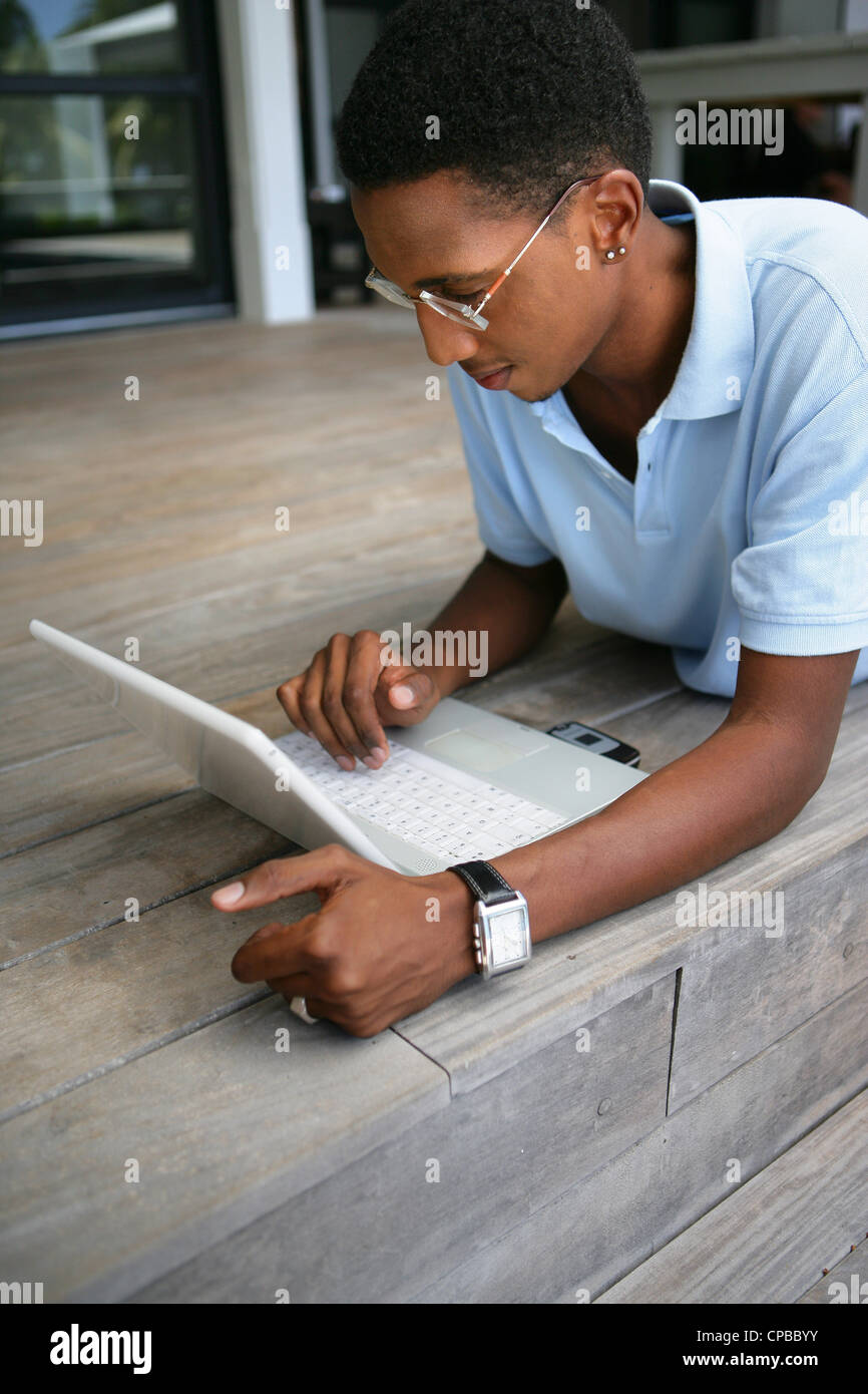 Man laying on his patio with a laptop Stock Photo - Alamy