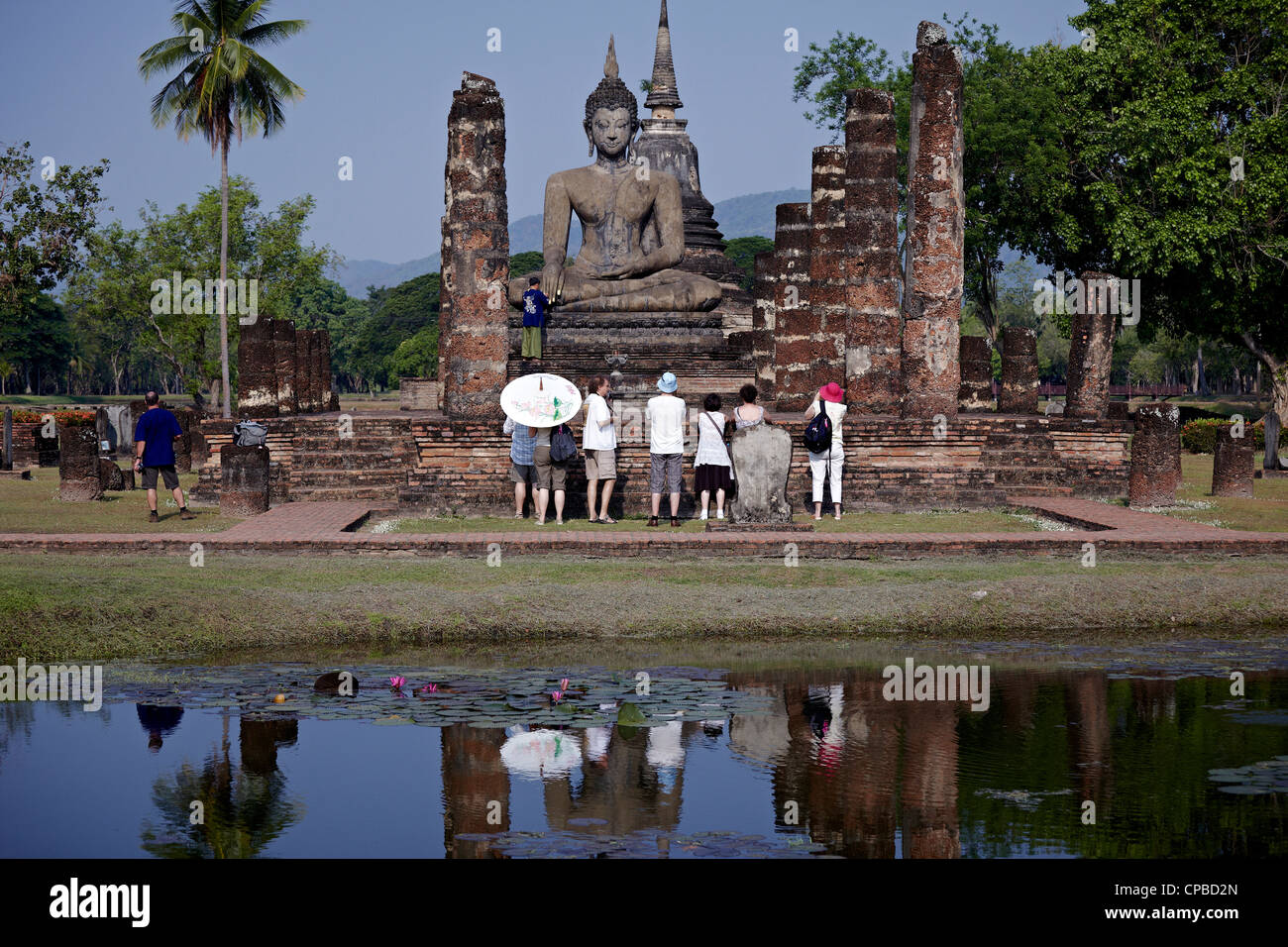 Wat Mahathat temple ruins Sukhothai. Tourists with Buddha statue. Capital of the Thailand Kingdom in the 13th and 14th centuries Thailand tourism Stock Photo