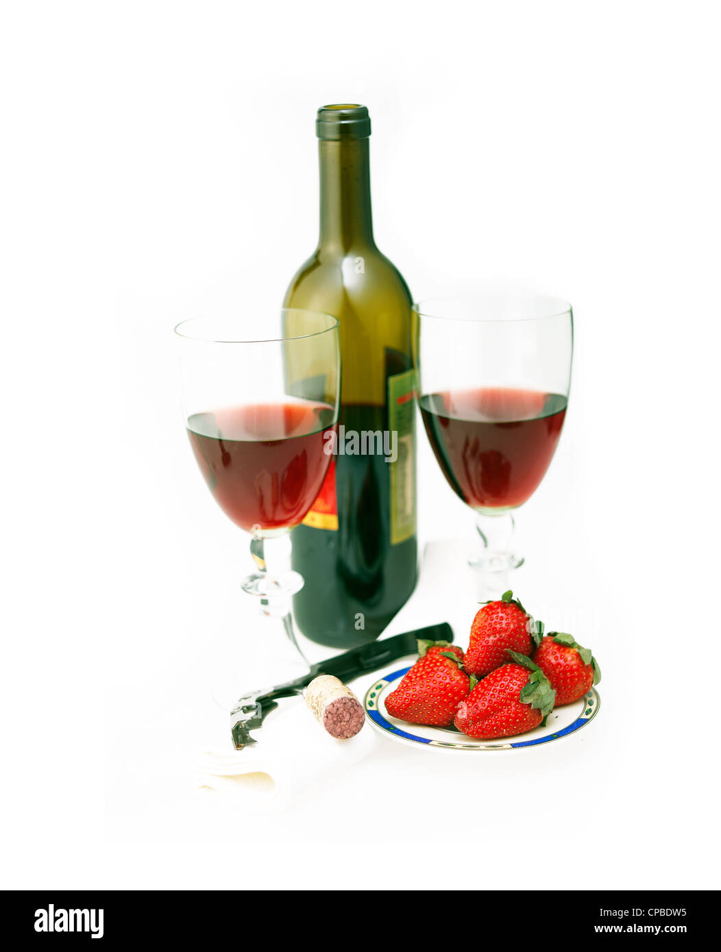 opened red wine bottle and two glasses and fresh strawberries isolated