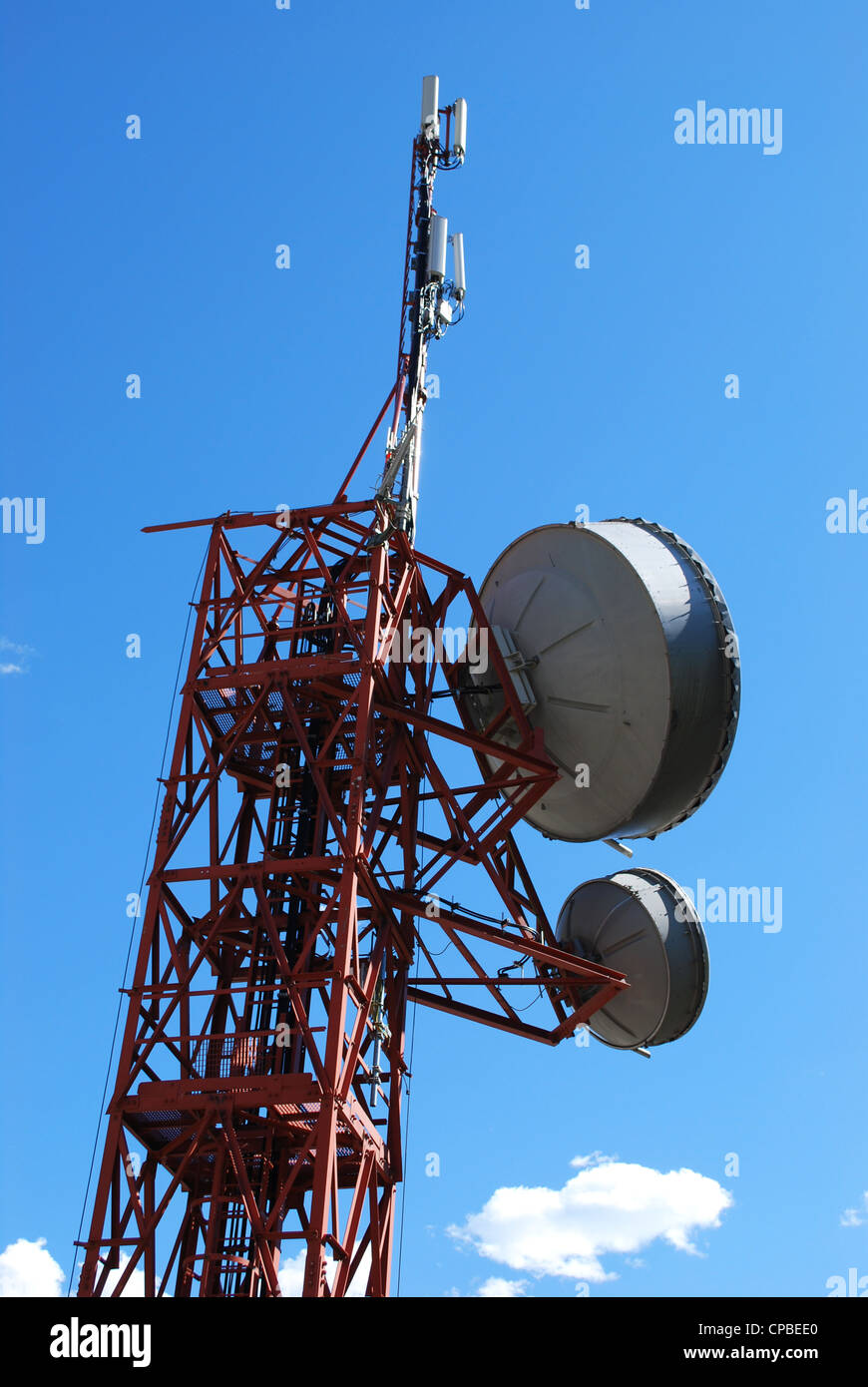 Huge communication antenna tower and satellite dishes against blue sky Stock Photo