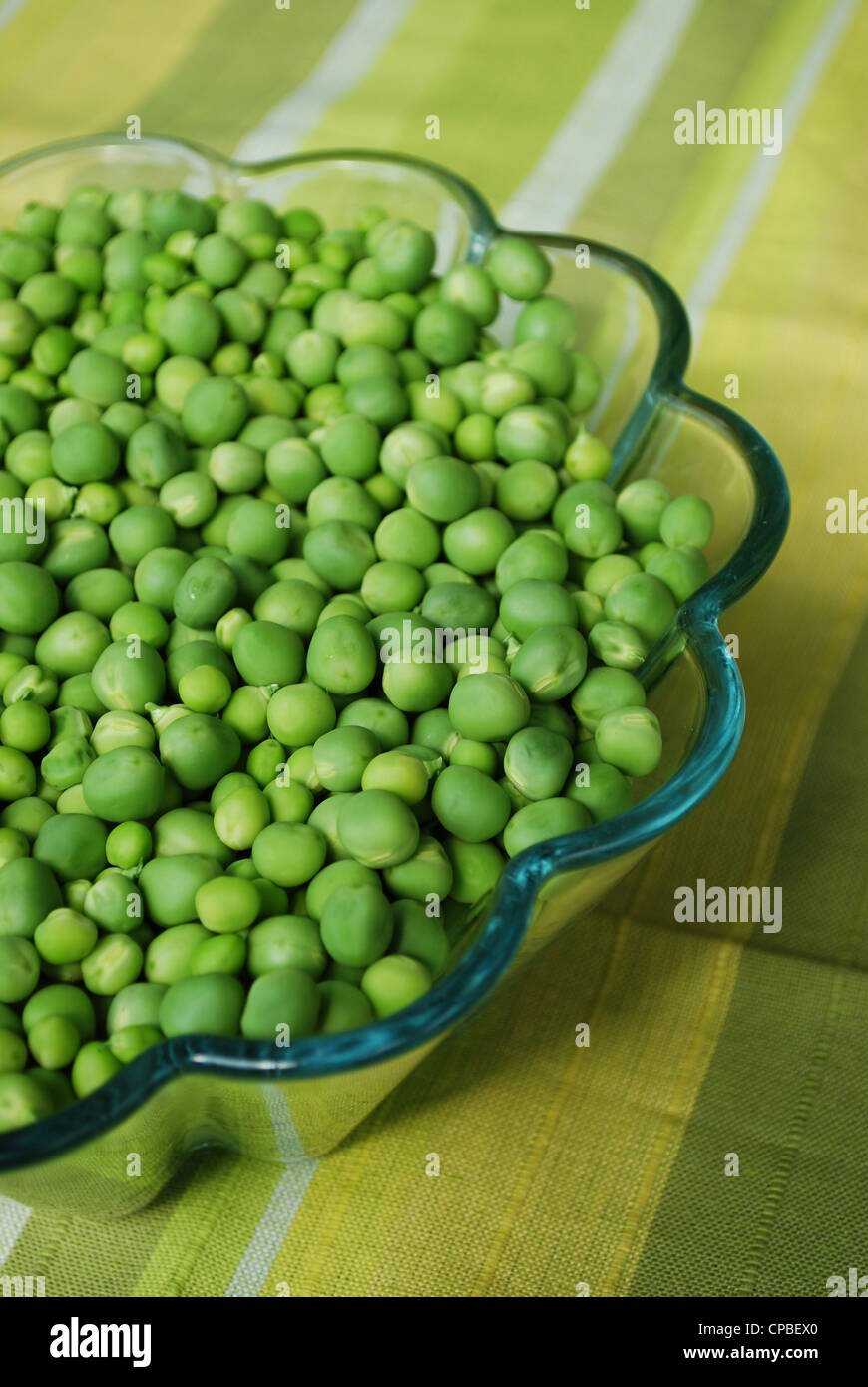 Shelled fresh ripe sweet green peas in a glass bowl Stock Photo